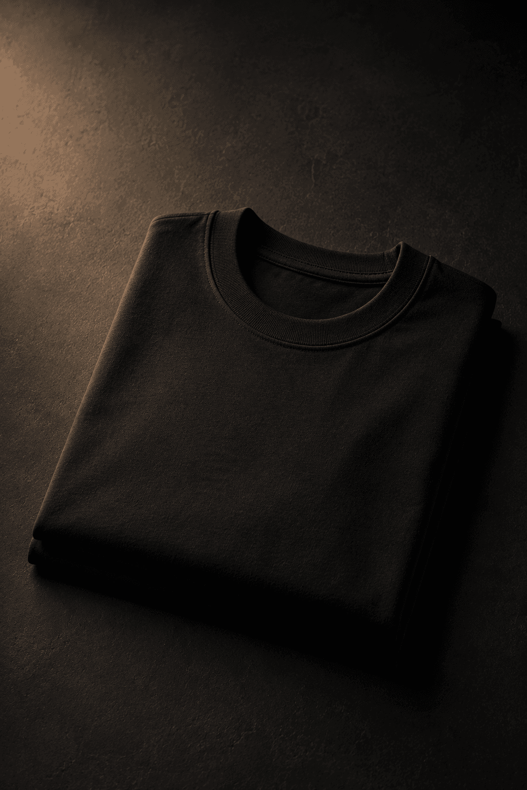 Heavyweight cotton tee in ink, folded against a studio backdrop